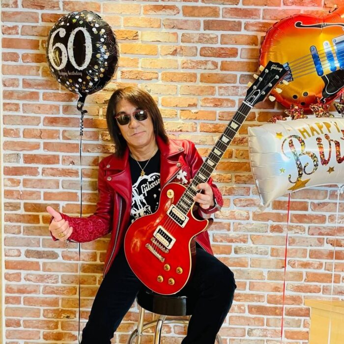 B'z松本孝弘さん60歳の還暦で赤いギター、レザージャケット、サングラス姿とメッセージとGUITAR BOOK発売